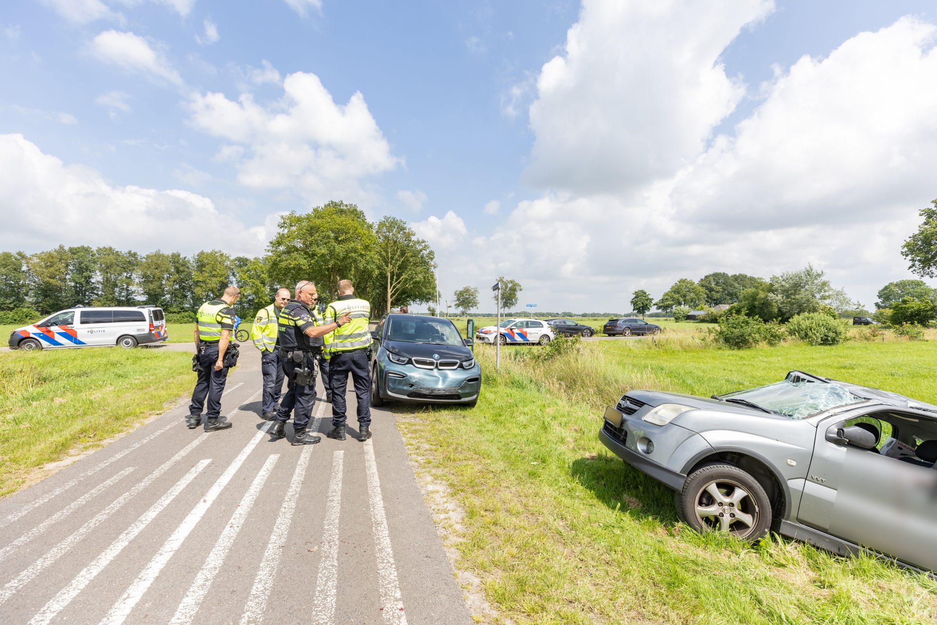 Auto over de kop na botsing op kruising