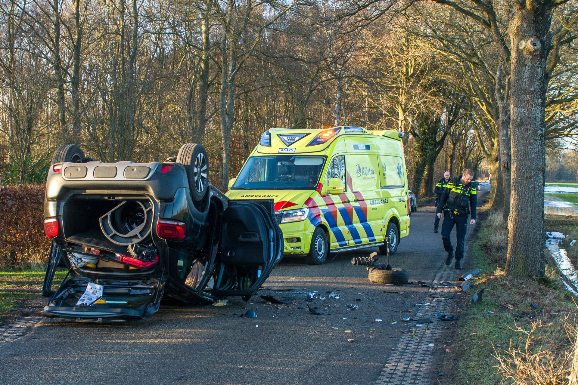 Auto over de kop na botsing met boom Zandhuizen