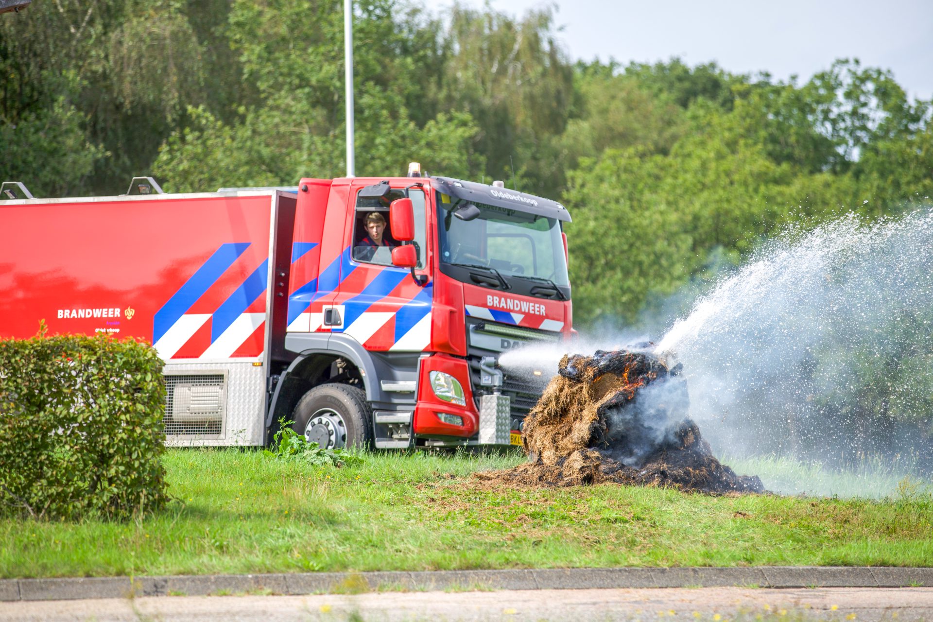 Brandweer blust balen op rotonde N351/N353 Oldeberkoop